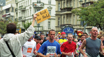 Berlin  eine Frau motiviert die Laeufer beim Marathon