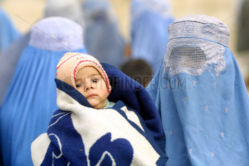 Frauen  verhuellt in Burkas mit Kleinkind.