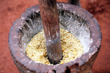 Mais wird in einem Moerser zu Maismehl gestampft.