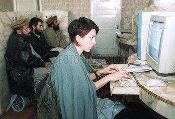 Eine Frau arbeitet im Internetcafe am Computer  Kabul.