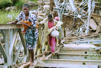 Frauen ueberqueren eine zerstoerte Bruecke  Angola.