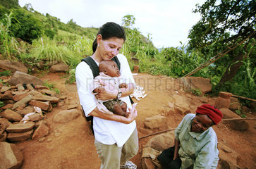 Helferin der JUH mit einem Kleinkind auf dem Arm