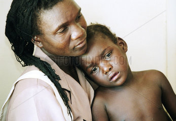 Eine Mutter haelt ihr krankes Kind in den Armen
