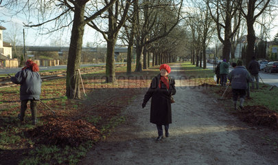 Eine Spaziergaengerin in einer Allee in Poznan