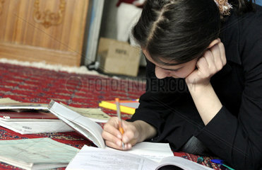 Afghanische  junge Schuelerin bei ihren Hausaufgaben