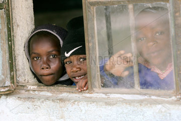 Afrikanische Schueler schauen aus dem Fenster eines Klassenraumes