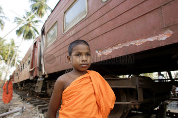 Buddhistische Moenche vor dem Zug- Wrack  Thelwatta