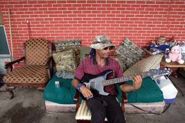 Mann spielt auf seiner E-Gitarre  nach dem Hurrikan Katrina