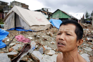 Verzweifeltes Tsunami Opfer vor seiner Notunterkunft