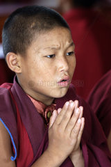 Junger buddhistischer Moench meditiert in einem Kloster