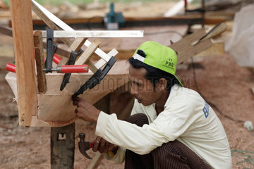 Mit Hilfe von Holzklemmen werden Holzplanken fuer den Schiffsbau zusammengehalten