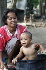 Indonesien  Java  eine Mutter waescht ihr Kleinkind in einer Plastikwanne