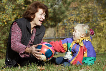 Berlin  eine Grossmutter spielt mit einem Maedchen Ball