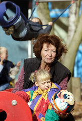 Berlin  eine Grossmutter spielt mit einem Maedchen auf einem Kinderspielplatz Ball