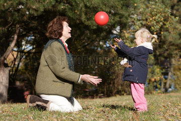 Berlin  eine Grossmutter spielt mit einem Maedchen Ball