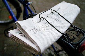 Zeitung klemmt auf einem Fahrradgepaecktraeger