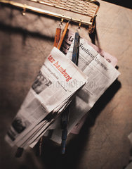 Zeitungen haengen an einer Garderobe