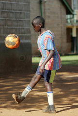 Kenia  eine Junge mit Orthese spielt Fussball in der Missionsstation Nyabondo