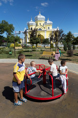 Republik Moldau  Gagausien  Comrat - Kinder auf Spielplatz am einzigen Platz der Stadt vor der russisch-orthodoxen Kathedrale