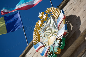Republik Moldau  Gagausien  Comrat - Das Wappen der Autonomen Region Gagausien auf dem Regierungsgebaeude  sowie Fahnen der Republik Moldau (L) und Gagausiens
