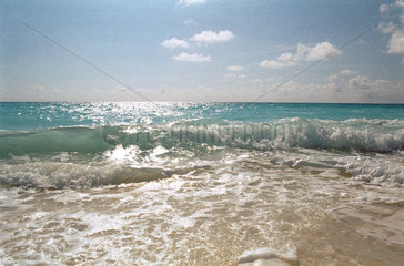 An den Strand aufschlagende Welle tuerkisblauen Meeres