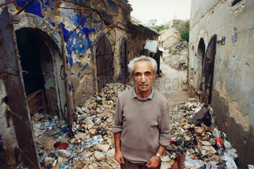 Mostar  Bosnien und Herzegowina  Mann zwischen Truemmern in der Altstadt