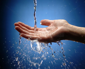 Frauenhand faengt Wasserstrahl auf