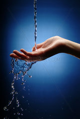 Frauenhand faengt Wasserstrahl auf