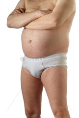dicker Mann mit behaartem Bauch in weisser Unterhose