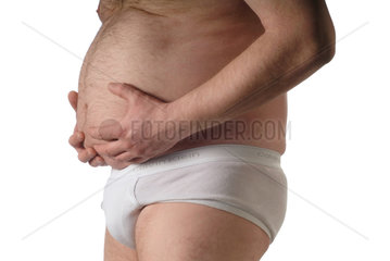 dicker Mann in weisser Unterhose haelt sich den Bauch