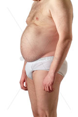 dicker Mann mit behaartem Bauch in weisser Unterhose im Profil