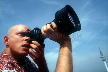 Konzentrierter Fotograf mit Spiegelreflexkamera