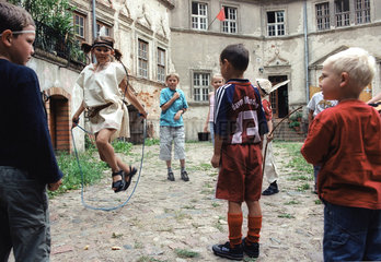 Kinder spielen mit einem Springseil