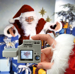 Weihnachtsmann mit Geschenken wird fotografiert