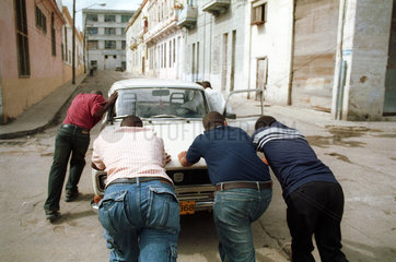 Kubanische Einwohner schieben ein Auto
