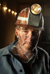 Grubenarbeiter mit Helm und Koerper voll Kohlenstaub