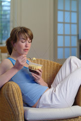 Junge Frau isst einen Pudding