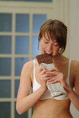 Junge Frau isst Schokolade