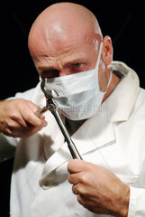 Hamburg  Ein Chirurg haelt eine Zange in seinen Haenden