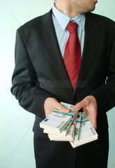 Ein Mann mit Geldbuendeln