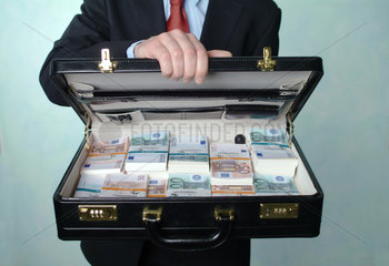 Ein Mann zeigt einen mit Euro-Buendeln gefuellten Koffer