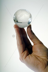 Eine Hand mit einem kleinen Fussball aus Glas