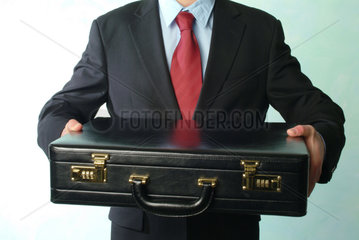 Ein Mann haelt eine schwarze Aktentasche