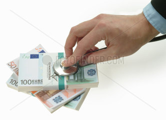Eine Hand untersucht den schwachen Euro