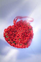 Ein Gesteck aus kuenstlichen Rosen in Herzenform
