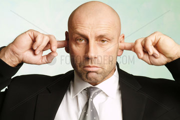 Mann mit Fingern in den Ohren