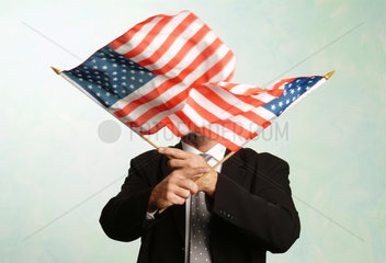 Mann schwenkt amerikanische Flaggen vor dem Gesicht