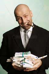 Mann posiert mit Zigarre und Geldbuendeln