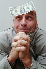Mann mit 1-Dollar-Note an der Stirn