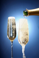 Champagner wird verschwenderisch in ein Glas gegossen